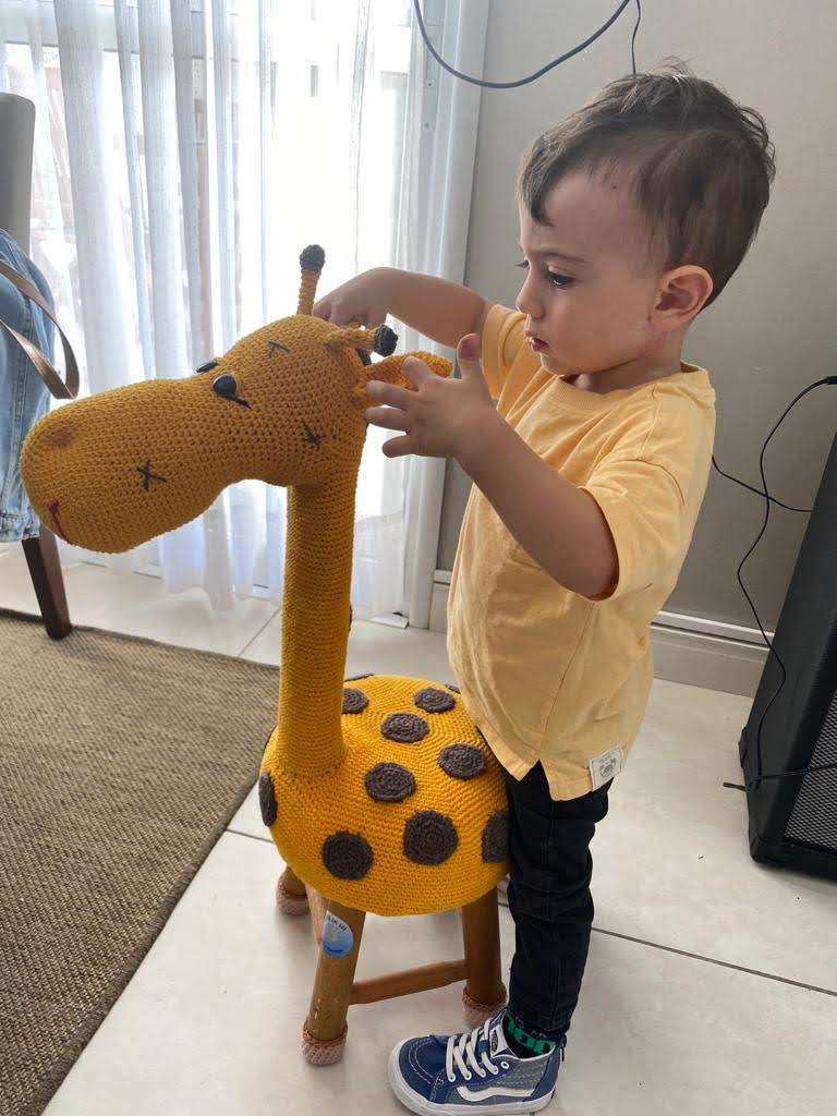 Criança com seu banquinho de crochê da Arte em Sol